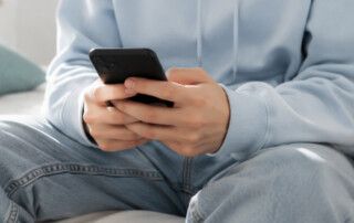 Joven utilizando un teléfono móvil relacionado con el impacto de la inteligencia artificial en la salud mental de adolescentes