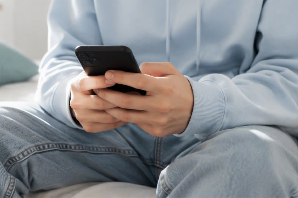 Joven utilizando un teléfono móvil relacionado con el impacto de la inteligencia artificial en la salud mental de adolescentes