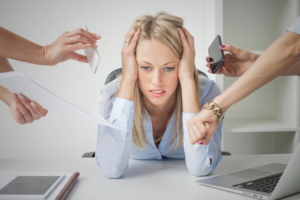 Mujer en oficina con signos de burnout y estrés laboral